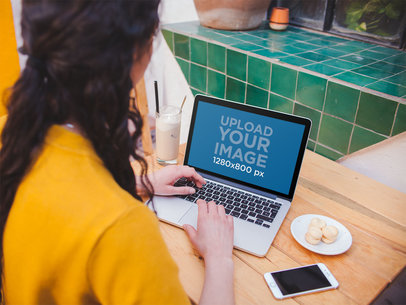 Girl with a Yellow Coat Using a MacBook Pro Mockup at a Cafe a19510