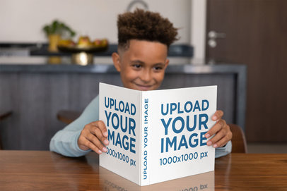 Square Book Mockup of a Young Boy Reading at Home
