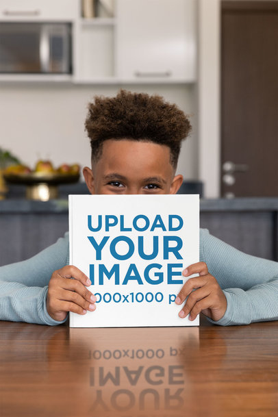 Mockup of a Little Boy Hiding His Face Behind a Square Book
