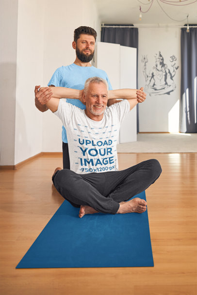 Heathered Tee Mockup of an Elderly Man with a Yoga Instructor