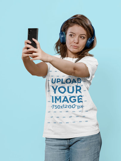T-Shirt Mockup of a Woman with Headphones Taking a Selfie in a Studio