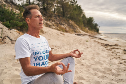 Round-Neck Tee Mockup of a Man Meditating on the Beach
