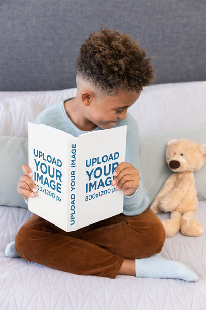 Book Mockup of a Boy Sitting in Bed With His Teddy Bear