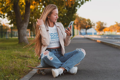 Crop Top Mockup Featuring a Woman Sitting on the Street and Checking Her Phone m18090-r-el2
