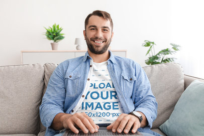 T-Shirt Mockup Featuring a Happy Man Sitting on a Couch While Working m19480-r-el2