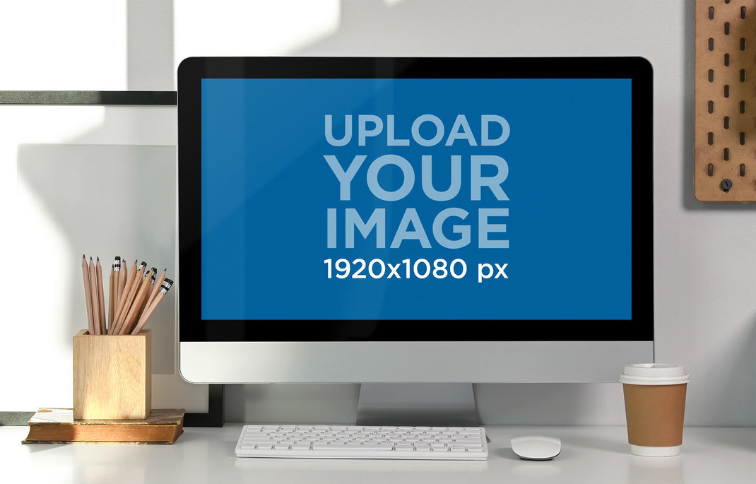 Mockup of an iMac Placed on a Desk with Pencils and a Coffee Cup
