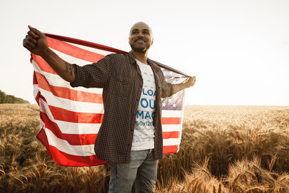 T-Shirt Mockup of a Happy Man Holding an American Flag Behind His Back