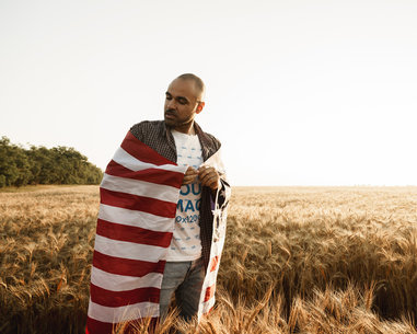T-Shirt Mockup of a Man Wrapping Himself with an American Flag