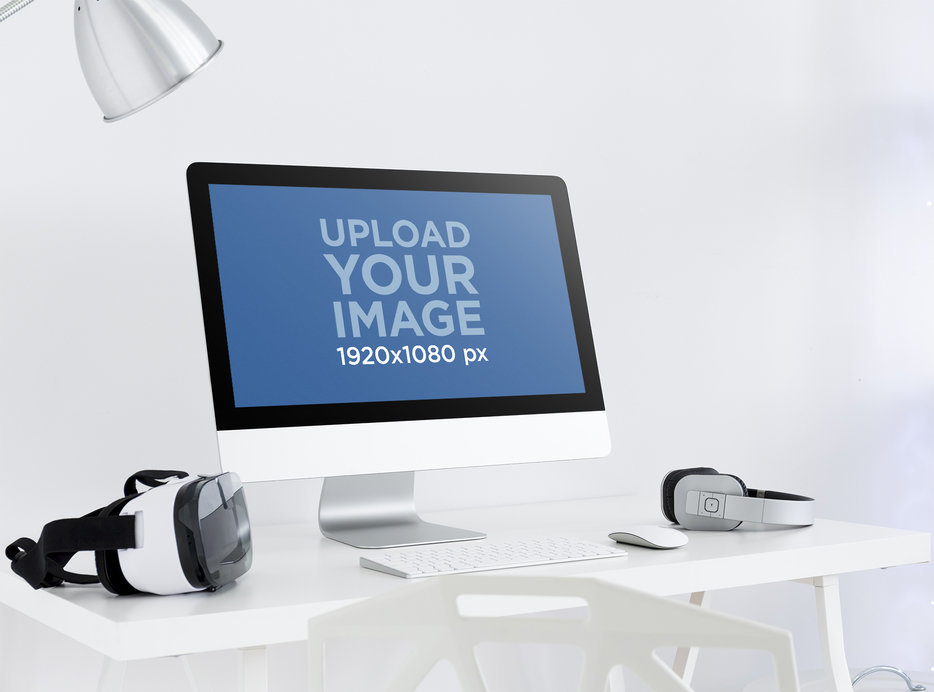 iMac Mockup Featuring a VR Headset and a Pair of Headphones Placed on a Desk 