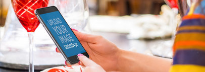 Mockup of a Woman Using an iPhone 6 in Portrait Position at Dinner