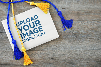 Mockup of a Book Placed Over a Wooden Surface Featuring Graduation Honor Cords m26004-r-el2