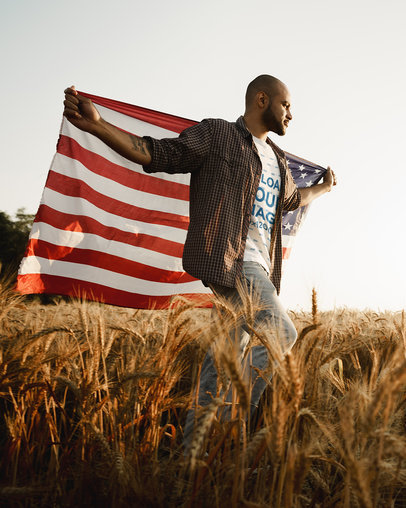 T-Shirt Mockup of a Man Waving an American Flag in a Field