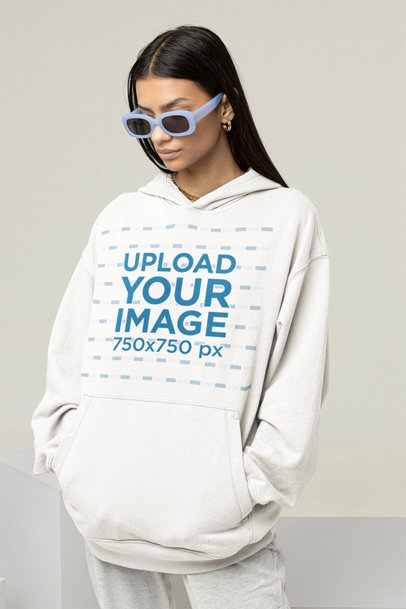 Hoodie Mockup Featuring a Cool Woman Posing in a Studio