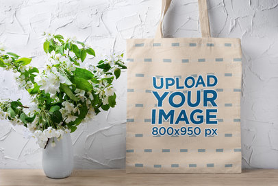 Mockup of a Tote Bag Placed Next to a Flower Vase