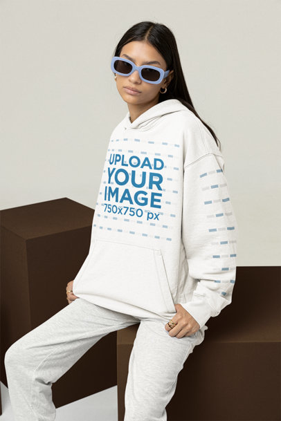 Mockup of a Woman with 90s Sunglasses Wearing a Hoodie