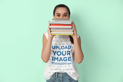 Sleeveless T-Shirt Mockup of a Young Woman Covering Half Her Face With a Pile Notebooks m22855 r-el2