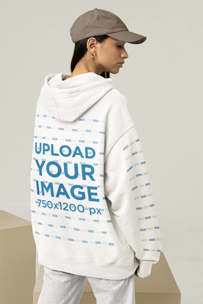 Mockup of a Woman Wearing an Oversized Hoodie With Customizable Sleeves at a Studio