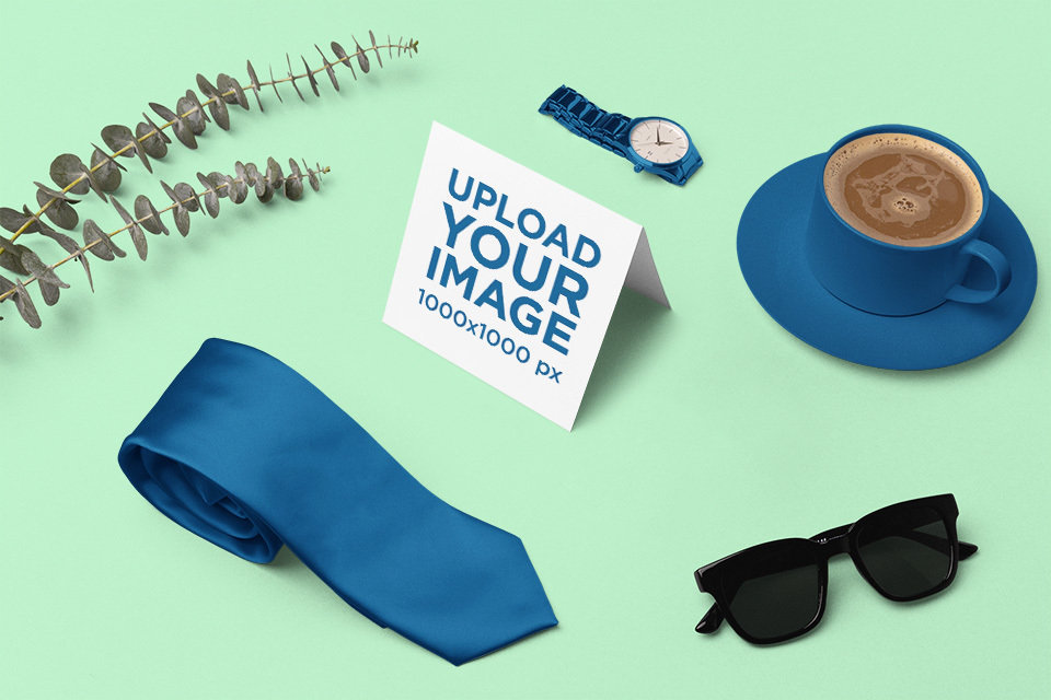 Mockup of a Greeting Card Surrounded by Apparel Accessories and Coffee