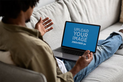 Mockup of a Man Using a MacBook While Sitting on a Couch
