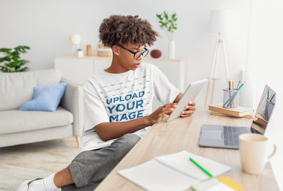 Round-Neck Tee Mockup of a Boy Using His Tablet at Home