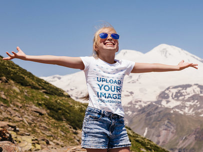 T-Shirt Mockup Featuring a Happy Girl with Sunglasses in the Mountains