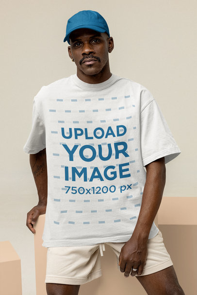 Mockup of a Serious Man Wearing an Oversized Tee and a Dad Hat at a Studio
