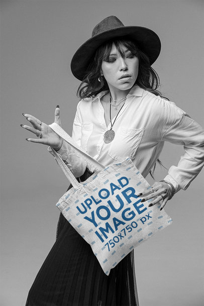 Tote Bag Mockup Featuring a Woman Posing at a Studio With a Serious Look