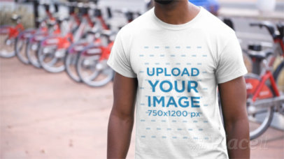 Young Black Man Wearing a T-Shirt Video Near a Bike Station in the City a12354
