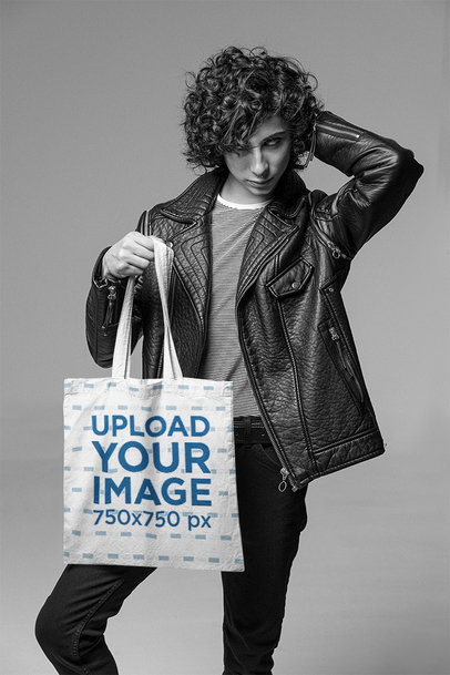 Tote Bag Mockup of a Stylish Man Posing at a Studio