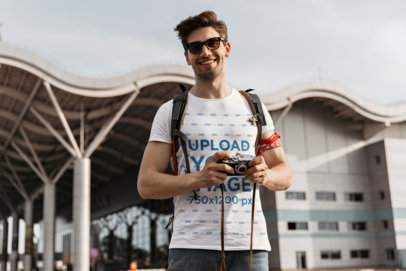 T-Shirt Mockup of a Happy Tourist Holding a Camera