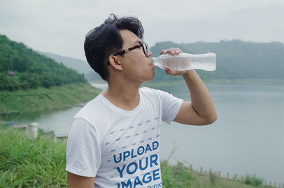 Basic Tee Mockup Featuring a Young Man Drinking Water by a Lake m17239 r-el2