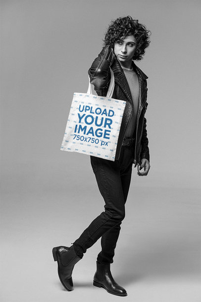 Mockup of a Curly-Haired Man Carrying a Tote Bag at a Studio
