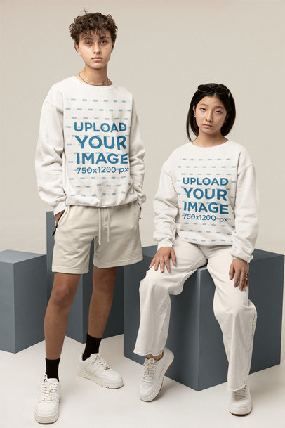 Mockup of a Young Woman and Man Wearing Sweatshirts at a Studio