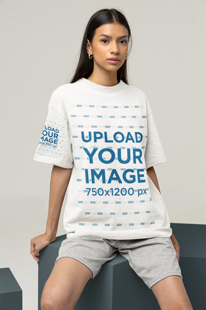 Tee Mockup of a Woman Sitting on a Cube at a Studio