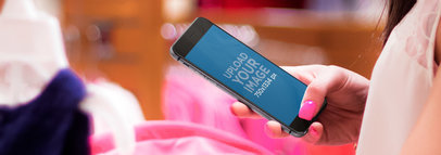 iPhone 6 in Portrait Position Mockup Featuring a Woman in a Baby Store