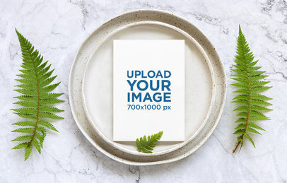 Wedding Program Mockup Placed Over a Plate Featuring a Marble Table With Fern Leaves m25024 r-el2