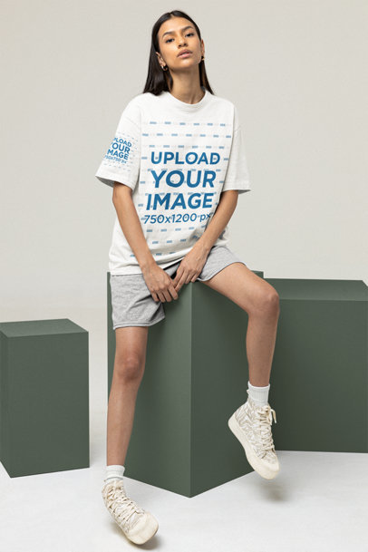 Oversized Tee Mockup Featuring a Woman Sitting on a Cube