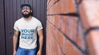 Hispter Dude Wearing a T-Shirt Video Standing Against a Black Door a12262