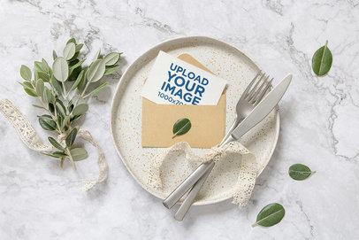 Mockup of a Wedding Program Lying in an Envelope Featuring a Marble Table and Botanic Ornaments