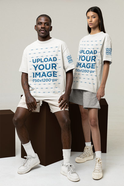 Mockup of a Man and a Woman Wearing a Tee with Customizable Sleeves at a Studio