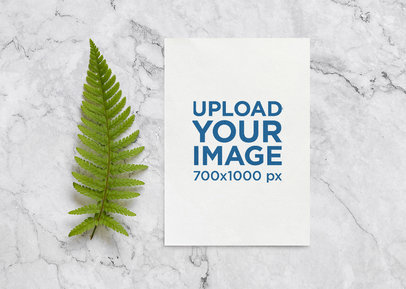 Mockup of a Wedding Program Lying on a Marble Table Next to a Fern Leaf m2508 r-el2