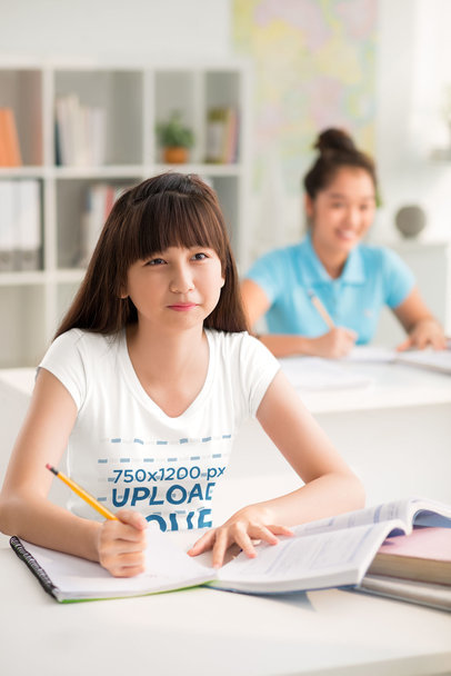 T-Shirt Mockup Featuring a Young Student Taking Notes in a Classroom