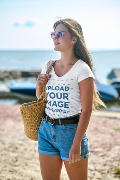 T-Shirt Mockup Featuring a Woman with Sunglasses at the Beach