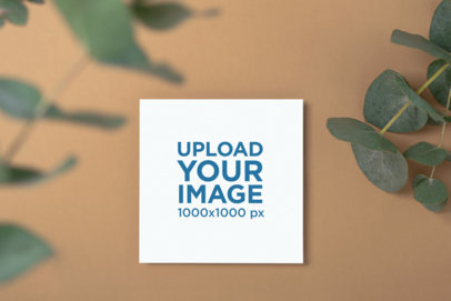 Mockup of a Wedding Program Placed on a Beige Surface Featuring Some Leaves