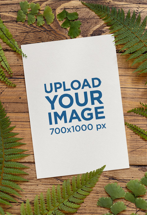 Mockup of a Wedding Program Placed Over a Wooden Table Featuring Fern Leaves