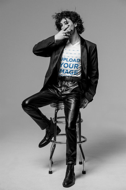 V-Neck Tee Mockup of a Chic Man Sitting on a Stool at a Studio