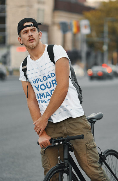 T-Shirt Mockup Featuring a Serious Man Riding a Bike in the City