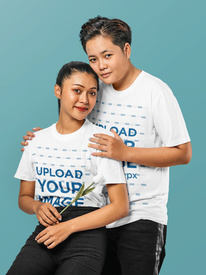 T-Shirt Mockup of Two Women Posing at a Studio With a White Rose