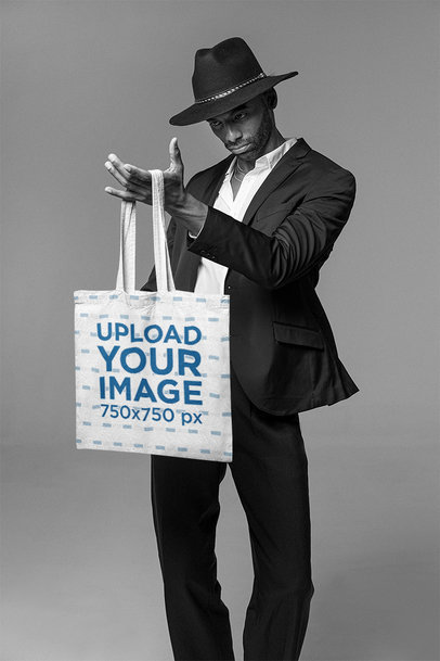 Mockup of a Tall Well-Dressed Man Staring at a Tote Bag m26392
