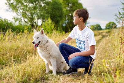 T-Shirt Mockup Featuring a Boy Posing Next to His Dog